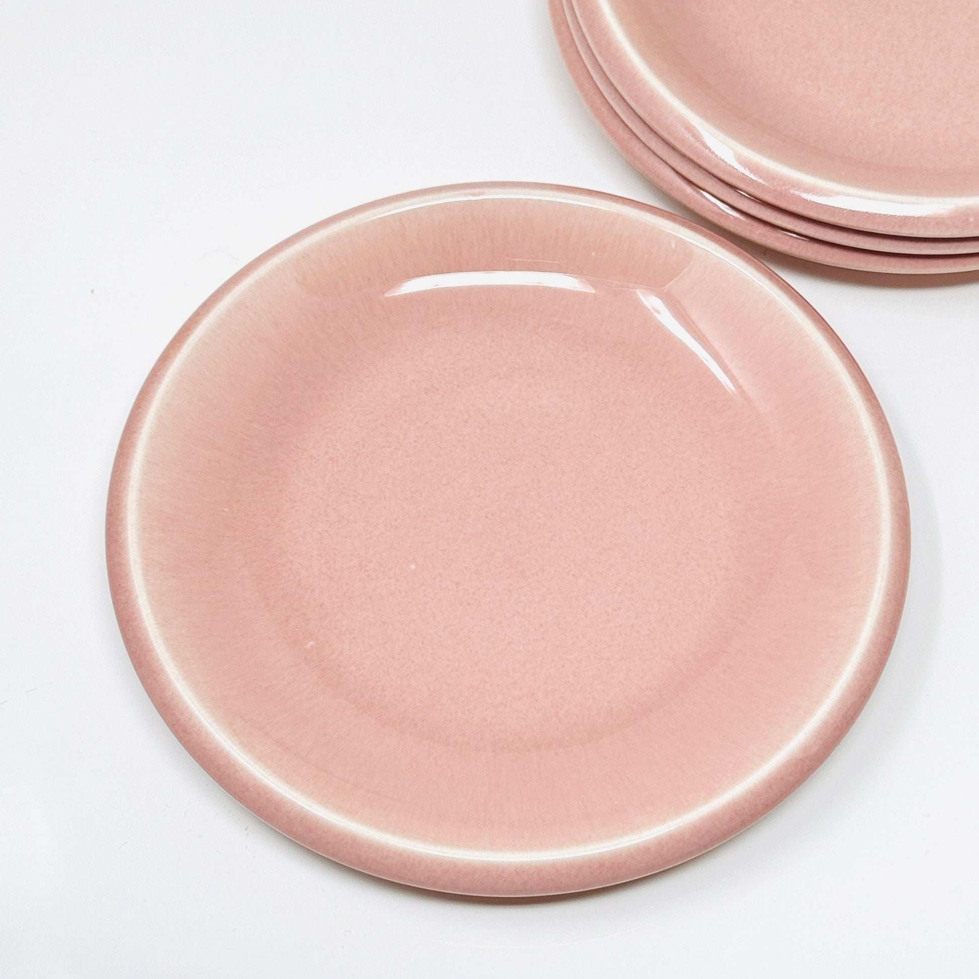 Set of pink ceramic plates on a white background