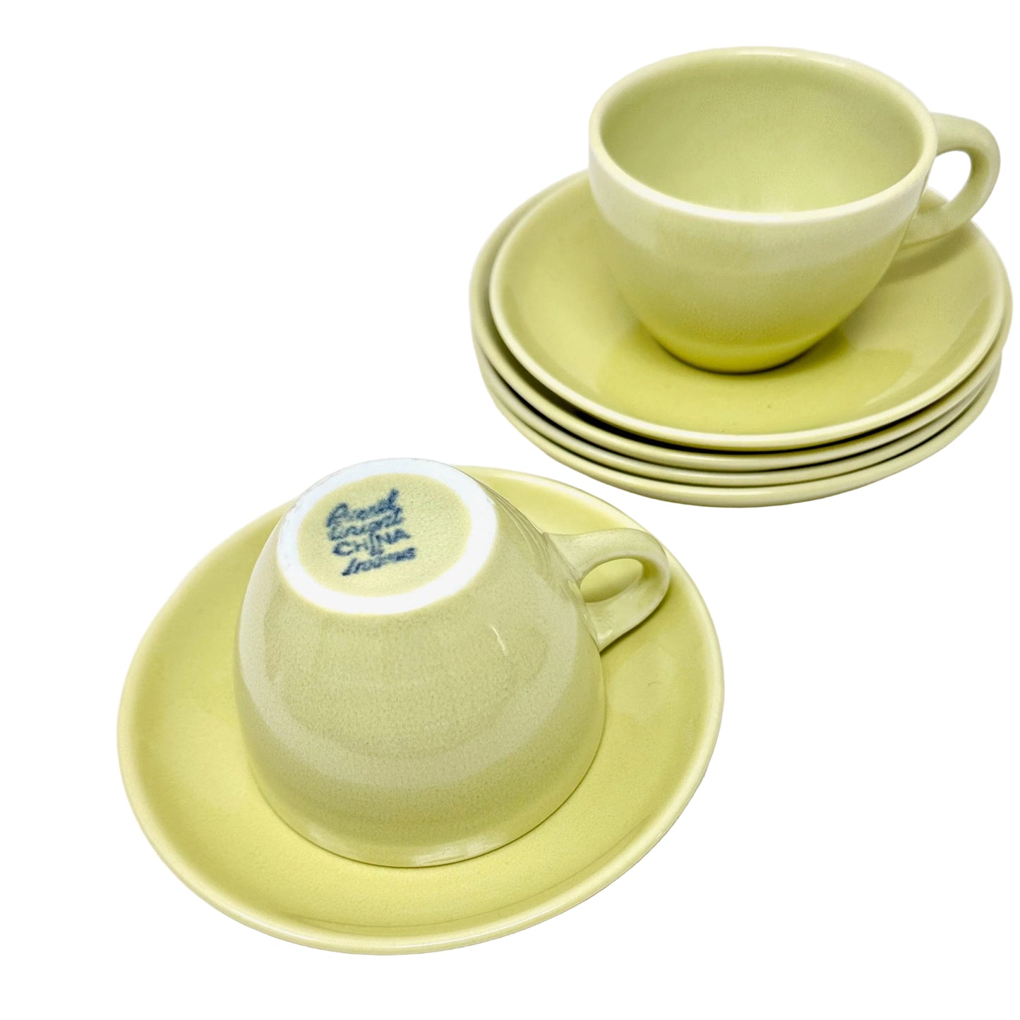 Set of green ceramic cups and saucers on a white background