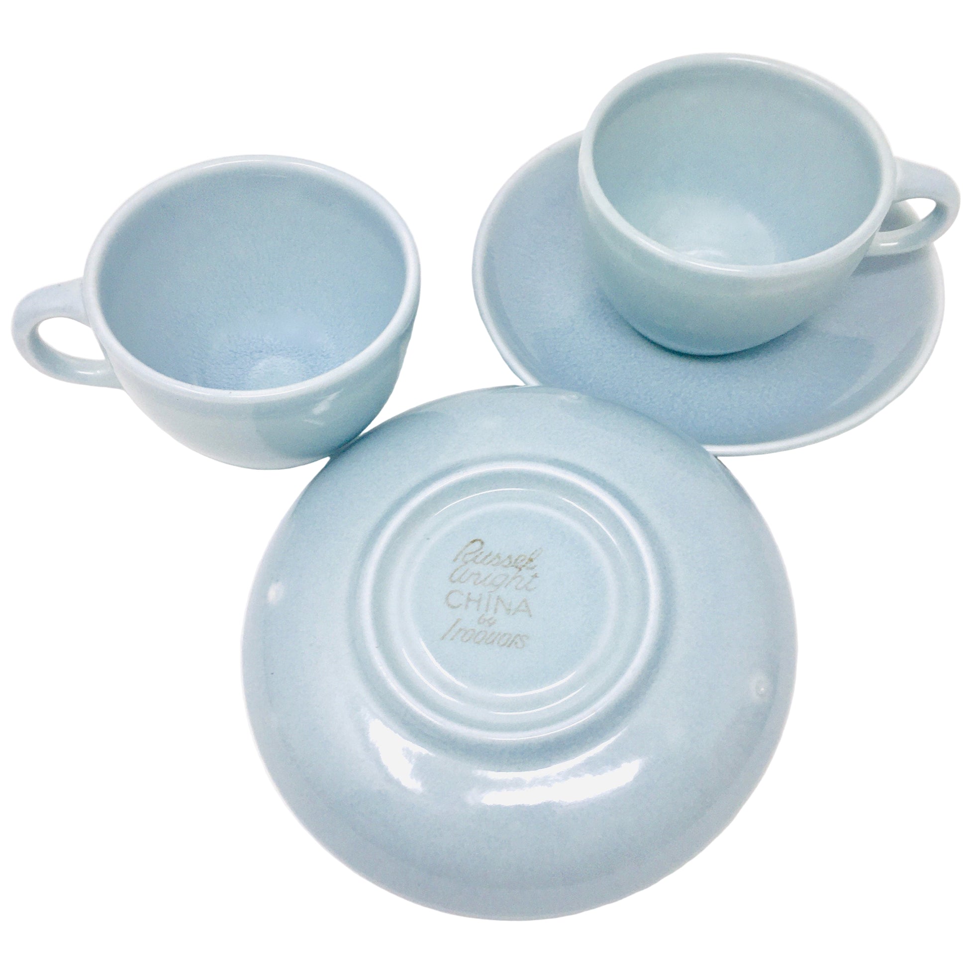 Set of light blue ceramic dishes including cups and saucers on a white background